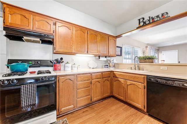 4702 Castana Ave, Lakewood, CA 90712 - kitchen with black dishwasher, range with gas cooktop, a sink, under cabinet range hood, and light wood-style flooring