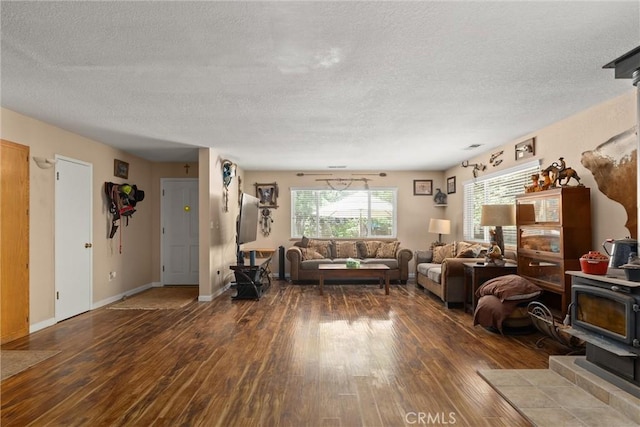 6176 Some Way, Magalia, CA 95954 - living area featuring hardwood / wood-style floors, a textured ceiling, a wood stove, and baseboards