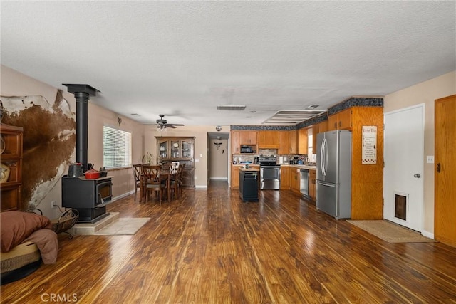 6176 Some Way, Magalia, CA 95954 - living room with a wood stove, dark wood-style floors, ceiling fan, a textured ceiling, and baseboards