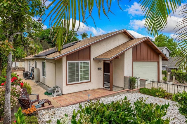252 Worthington St, Spring Valley, CA 91977 - view of front of home with a garage, roof with shingles, fence, roof mounted solar panels, and stucco siding