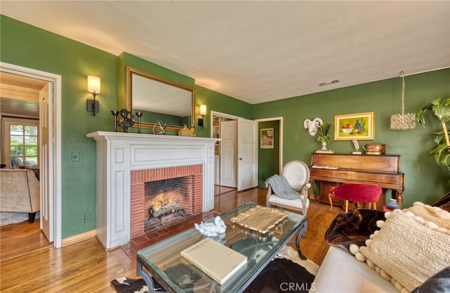 living area featuring a fireplace, wood finished floors, and baseboards