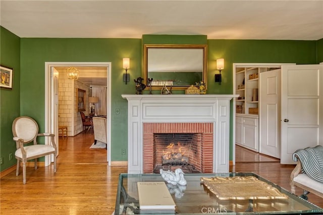 living room featuring wood finished floors, a fireplace, and baseboards
