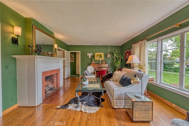 living room with hardwood / wood-style flooring, a fireplace, and baseboards