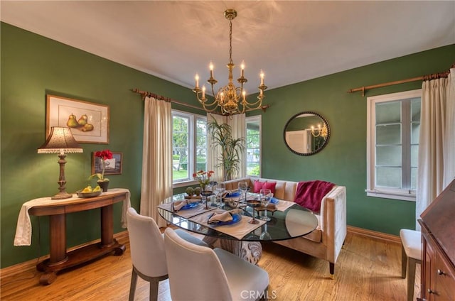 dining room with a chandelier, wood finished floors, and baseboards