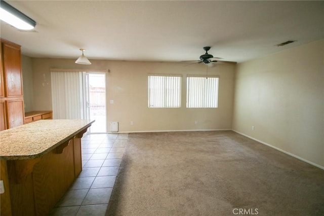 1680 Elmbridge Ln, Hemet, CA 92545 - kitchen with a ceiling fan, light countertops, brown cabinetry, a kitchen island, and baseboards