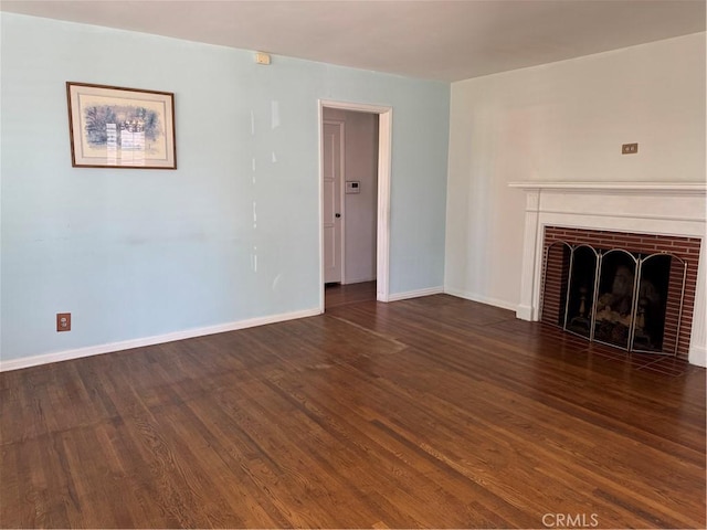 unfurnished living room featuring wood finished floors, baseboards, and a fireplace