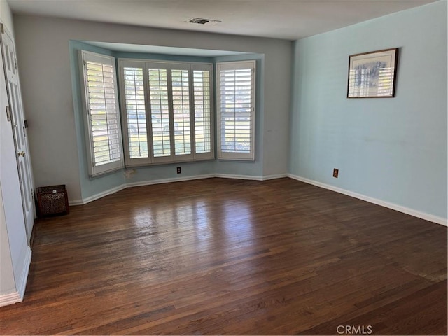 spare room featuring wood finished floors and baseboards
