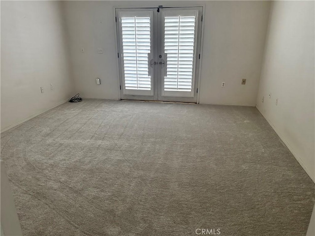carpeted spare room with french doors
