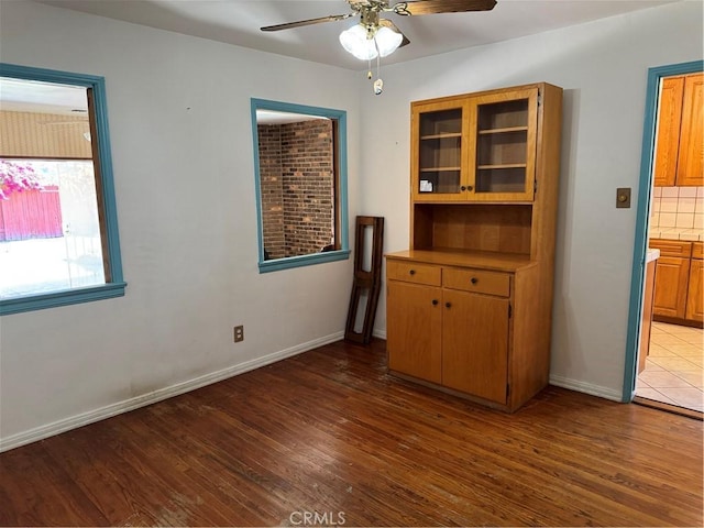 spare room featuring a ceiling fan, wood finished floors, and baseboards