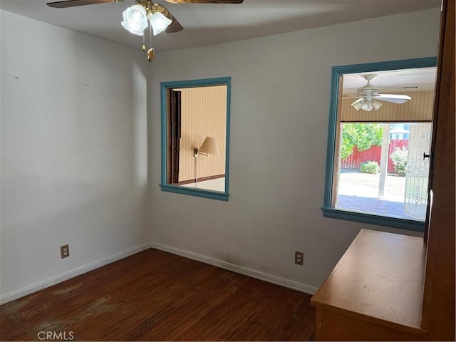 spare room featuring a ceiling fan, wood finished floors, and baseboards