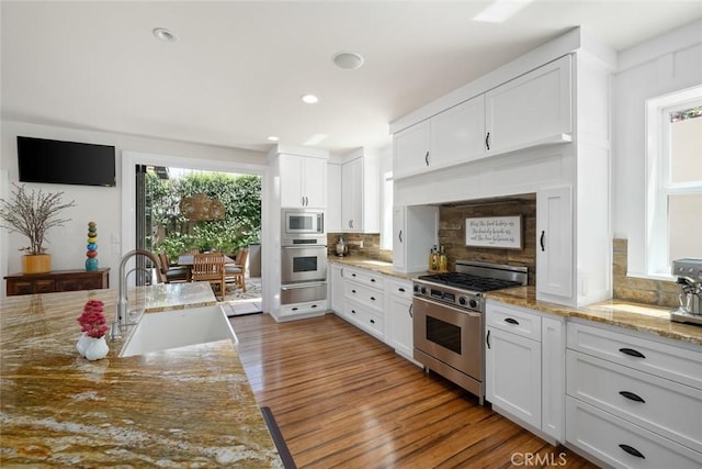 863 Greystone Pl, San Luis Obispo, CA 93401 - kitchen with stainless steel appliances, a sink, a warming drawer, decorative backsplash, and white cabinetry