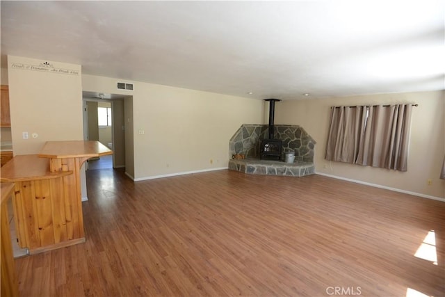 3809 Arroyo Trl, Frazier Park, CA 93225 - unfurnished living room featuring wood finished floors, baseboards, and a wood stove