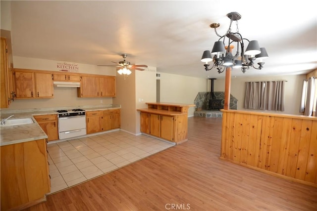 3809 Arroyo Trl, Frazier Park, CA 93225 - kitchen with white gas range, a sink, light wood finished floors, light countertops, and a chandelier