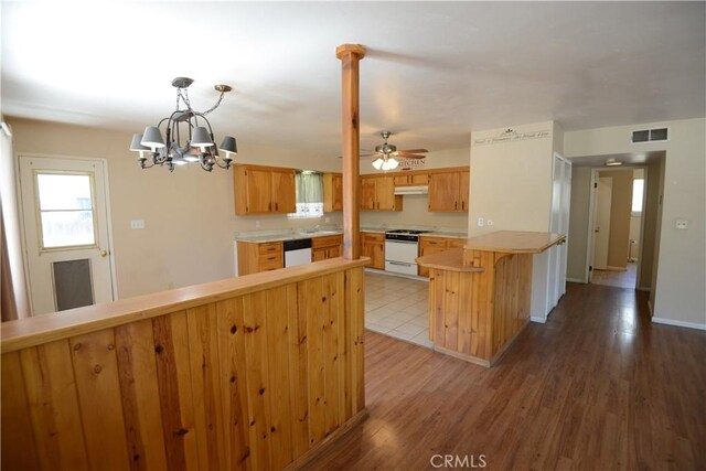 3809 Arroyo Trl, Frazier Park, CA 93225 - kitchen with a peninsula, under cabinet range hood, light countertops, white appliances, and wood finished floors
