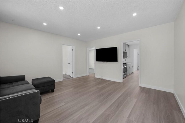 10117 Sharp Ave, Arleta, CA 91331 - living area featuring light wood finished floors, baseboards, recessed lighting, and a textured ceiling