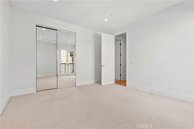 unfurnished bedroom featuring light carpet, recessed lighting, and baseboards