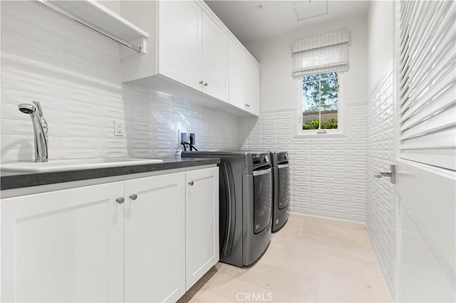laundry area with cabinet space, washer and dryer, tile walls, and a wainscoted wall