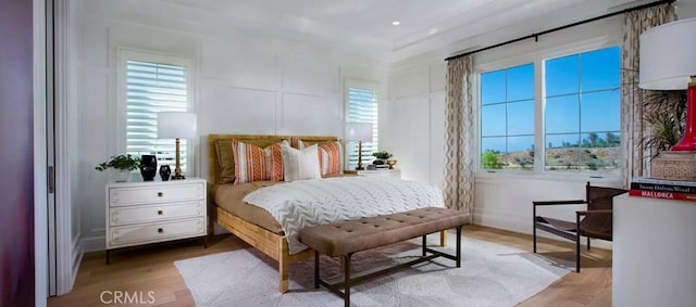 bedroom featuring multiple windows and wood finished floors