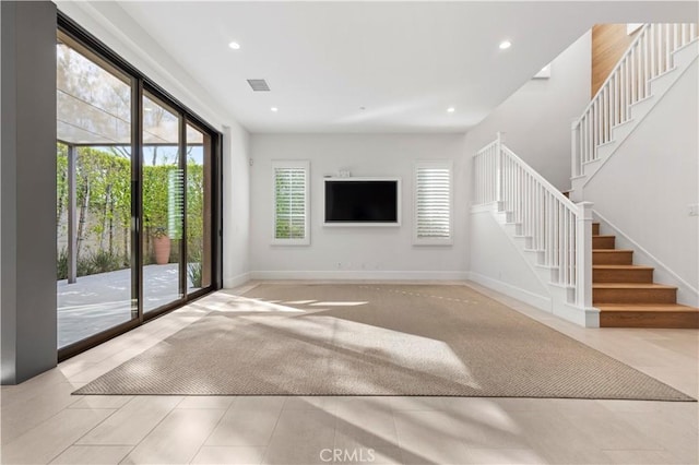 unfurnished living room with stairway, healthy amount of natural light, recessed lighting, and baseboards