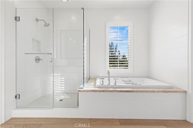 full bathroom featuring a stall shower and a bath