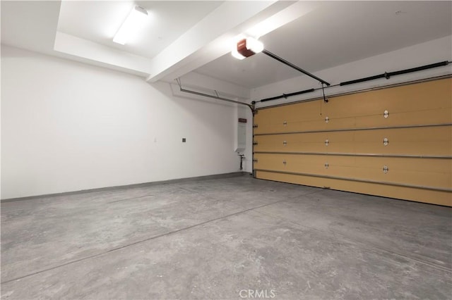 garage with a garage door opener and baseboards