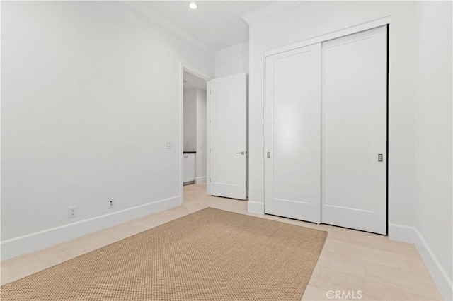 unfurnished bedroom with baseboards, a closet, recessed lighting, and crown molding