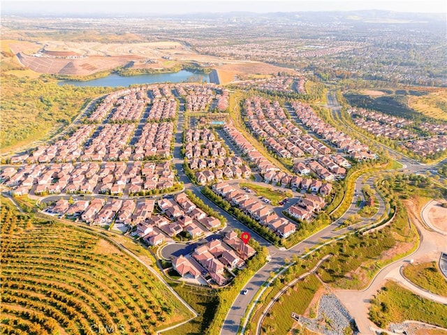 aerial view of property and surrounding area featuring a nearby body of water and nearby suburban area