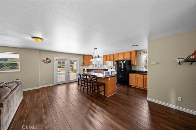 27876 Twilight Ct, Murrieta, CA 92563 - kitchen with white appliances, open floor plan, dark wood-type flooring, dark countertops, and a textured ceiling
