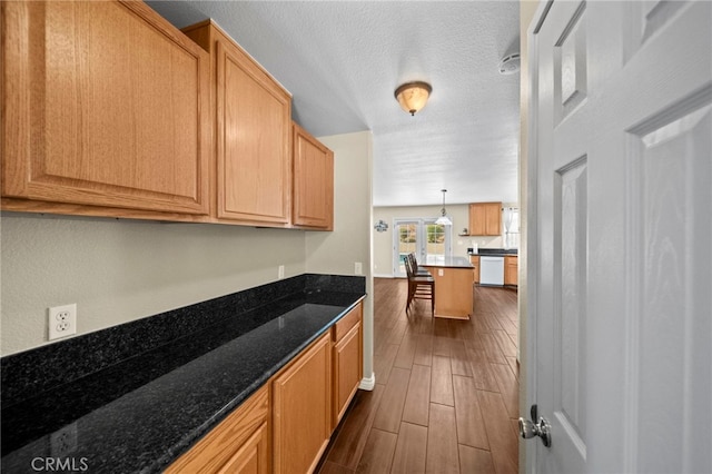 27876 Twilight Ct, Murrieta, CA 92563 - kitchen featuring dishwasher, dark wood-style floors, a textured ceiling, and dark stone counters