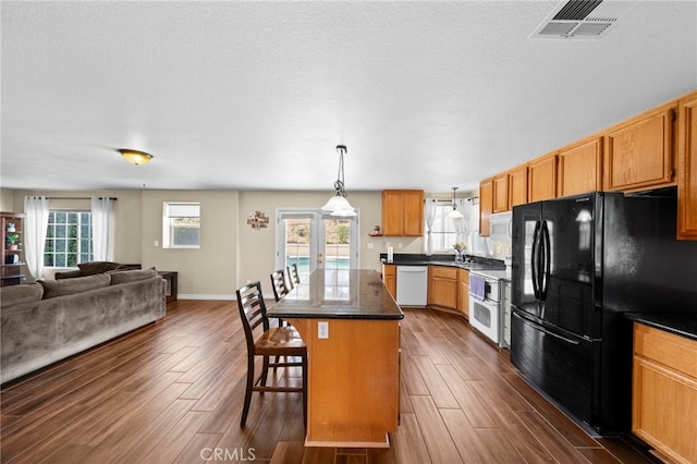 27876 Twilight Ct, Murrieta, CA 92563 - kitchen featuring white appliances, dark wood-style floors, a kitchen island, a kitchen bar, and open floor plan