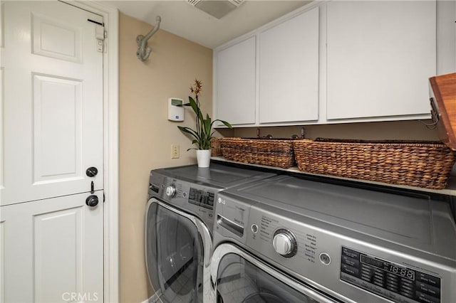 washroom featuring cabinet space and separate washer and dryer