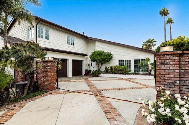 mid-century home featuring an attached garage and concrete driveway