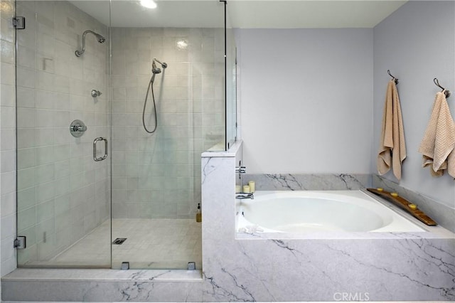 bathroom featuring a stall shower and a garden tub