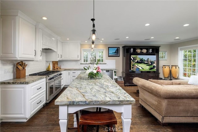 kitchen featuring stainless steel appliances, white cabinets, light stone counters, backsplash, and recessed lighting