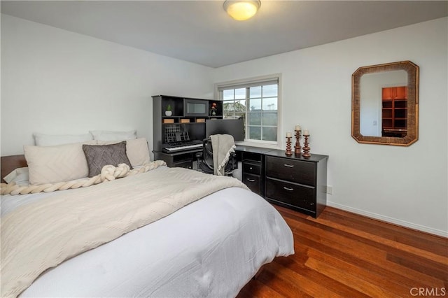 bedroom with dark wood-style floors and baseboards