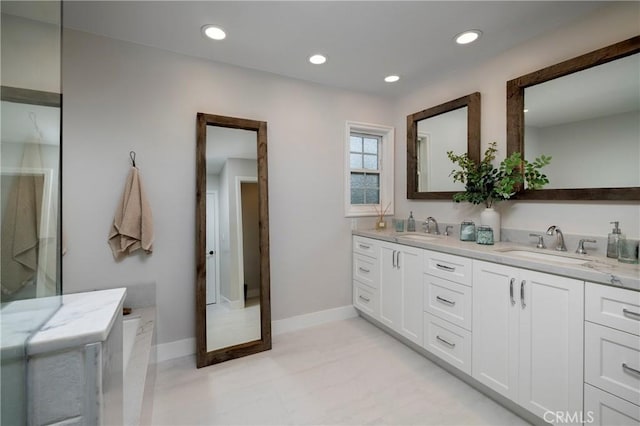 bathroom featuring double vanity, recessed lighting, and baseboards