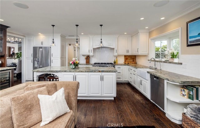 kitchen with wine cooler, appliances with stainless steel finishes, a sink, dark wood-style flooring, and a kitchen island