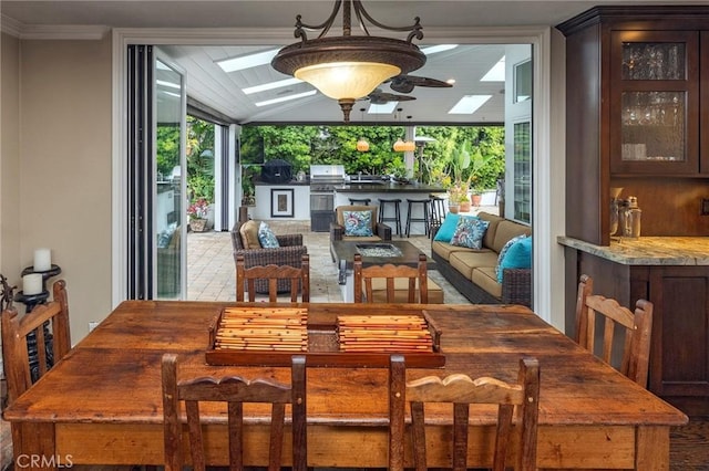 dining area with a skylight, plenty of natural light, lofted ceiling, and a ceiling fan