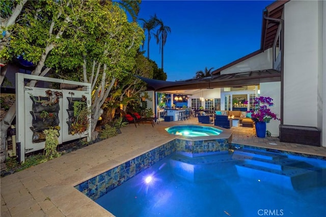 swimming pool featuring an in-ground hot tub, a patio area, and an outdoor living space