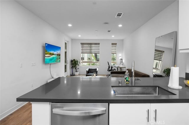 kitchen featuring a sink, dark countertops, stainless steel dishwasher, white cabinets, and recessed lighting