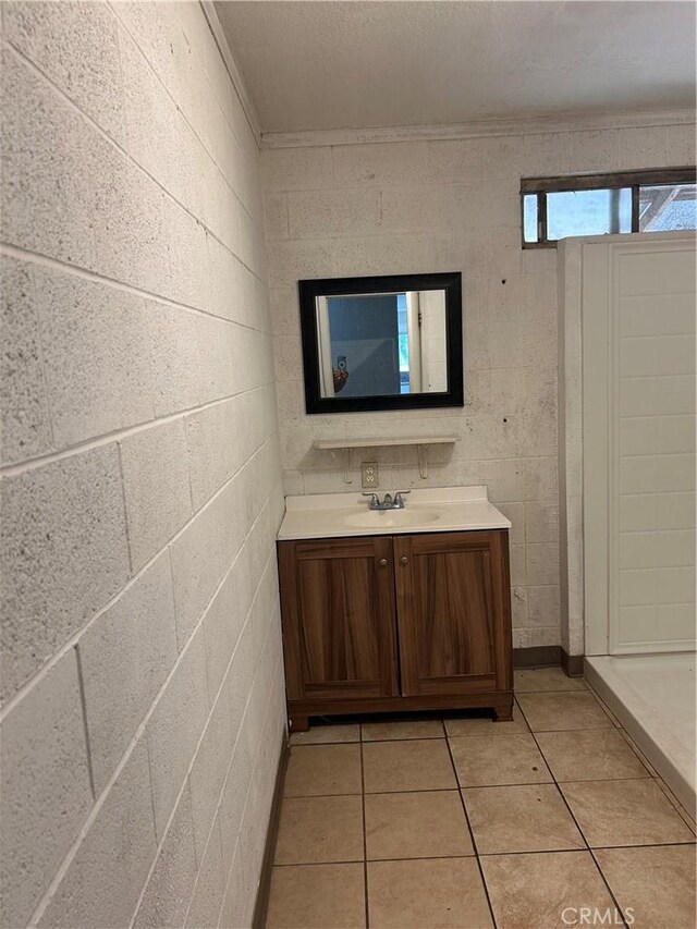 full bathroom featuring vanity, tile patterned flooring, a shower stall, and ornamental molding