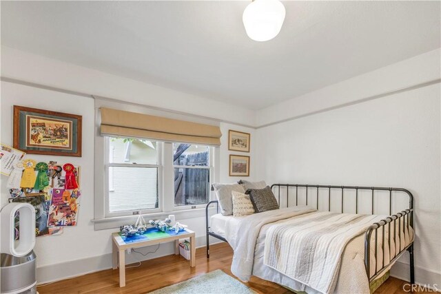 bedroom with wood finished floors and baseboards