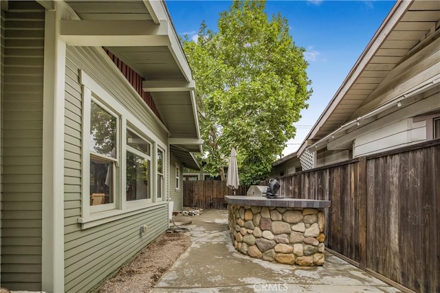 view of side of home featuring fence and a patio