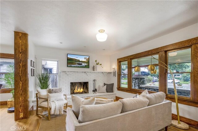 living area with wood finished floors, a fireplace, and baseboards