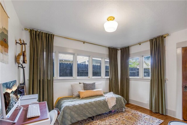 bedroom with light wood-style flooring and baseboards