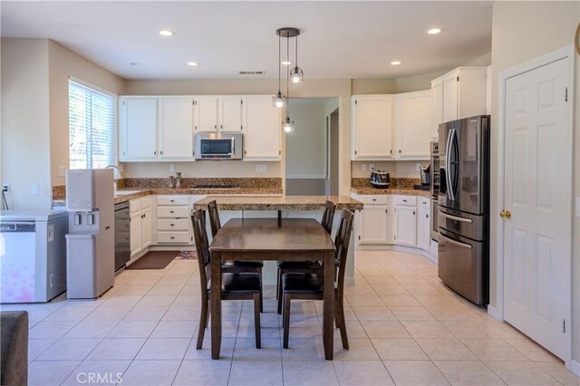 kitchen with appliances with stainless steel finishes, white cabinetry, decorative light fixtures, recessed lighting, and light stone countertops