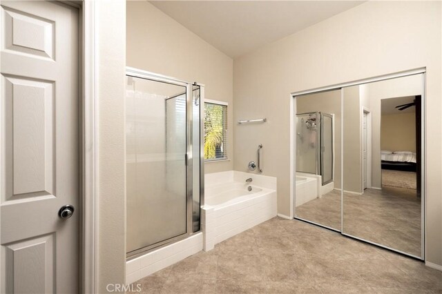 full bath featuring a stall shower, a garden tub, lofted ceiling, and tile patterned floors