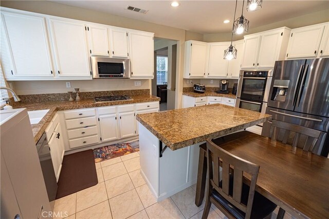 kitchen with stainless steel appliances, white cabinets, a sink, and recessed lighting