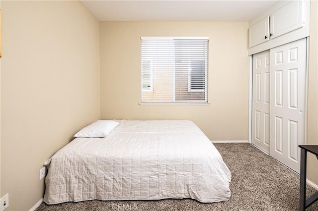 carpeted bedroom featuring baseboards and a closet