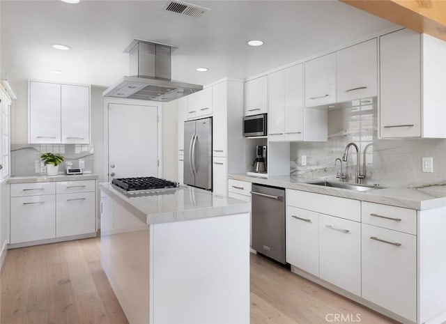 33156 Ocean Bright, Dana Point, CA 92629 - kitchen featuring appliances with stainless steel finishes, island exhaust hood, a sink, light wood-type flooring, and white cabinetry